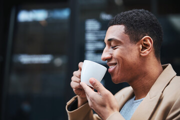 Pleased male person enjoying favorite smell of coffee