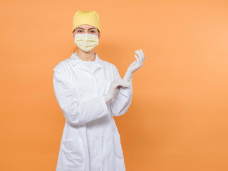 friendly nurse with mask putting a gloves in white robe