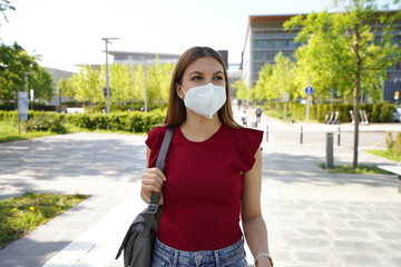 Business woman in modern city street wearing KN95 FFP2 protective mask looking to the side