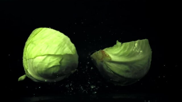 The super slow motion of the cabbage fork splits into half. On a black background. Filmed on a high-speed camera at 1000 fps. High quality FullHD footage