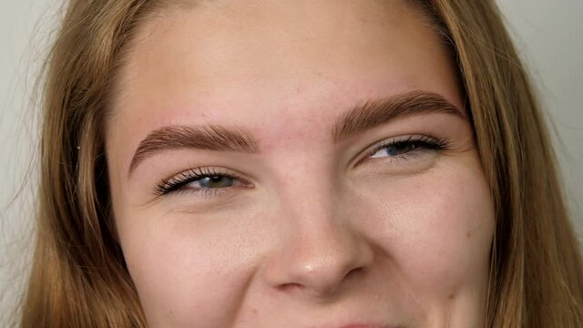 Happy girl smiling face looking at camera. Head shot close up portrait. Beautiful young human face with white skin. Female nature beauty. Woman laughs and playfully looks at the camera