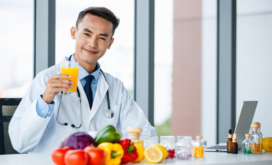 Asian nutritionist showing orange and juice