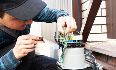 Technician man installing and checking the function of automatic gate