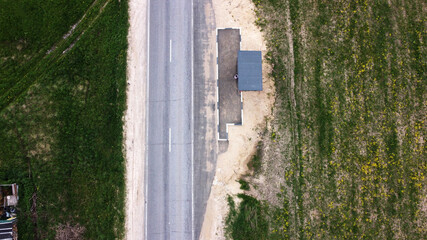 The road goes through the forest. View from above. The road passes through Russia. Roads of Russia. Dangerous section of the road. 