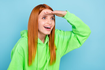 Photo of shiny impressed woman wear green sweatshirt arm forehead looking far away empty space isolated blue color background