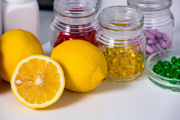 Glassware with vitamins near lemons