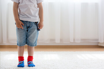 Child feet with different socks standing in rows, kids wearing different socks