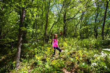 Naklejka na ściany i meble Portrait of adorable hiking little girl on spring day in forest