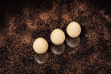 Chocolate candies on a dark background with reflection. Piece by piece and as a whole. Filling of nuts and fruits.