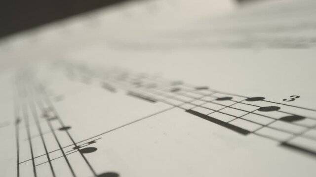 Tracking Shot Over Bars On a Music Sheet Book Page 