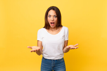 young hispanic woman feeling extremely shocked and surprised