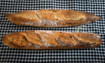 Fresh and crispy baguette on a black gingham napkin