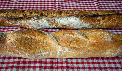Fresh and crispy baguette on a red gingham napkin