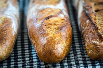 Fresh and crispy baguette on a black gingham napkin
