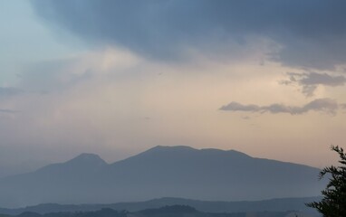 Montagne dell’appennino in un azzurro e luminoso tramonto di nuvole e foschia
