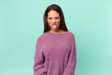 young hispanic woman feeling disgusted and irritated and tongue out