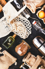 Recyclable, reusable eco friendly bags, package, bottles, cans and storage containers, mesh bag. Gray table, top view. Zero waste, plastic free and sustainable life concept