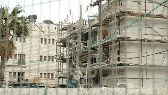 A large construction site of a Jewish residential project within the Sheikh Jarrah neighborhood, Palestinian workers for Jewish settlers, a middle Eastern paradox, Jerusalem, Israel.