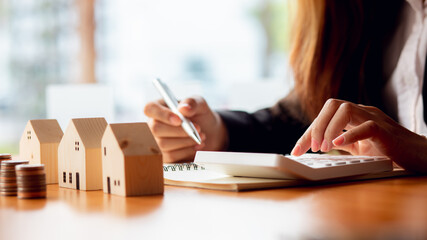 Female woman hands holding home model, small miniature white toy house. Mortgage property insurance dream moving home and real estate concept