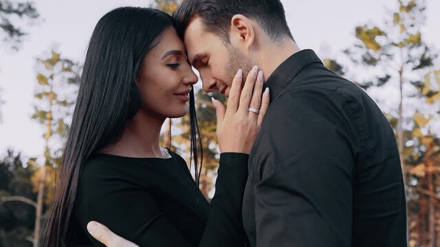 The close-up of the couple in love, the woman caresses the face of the man she loves, they smile happily deep in each other's eyes. Lifestyle concept of young lovers