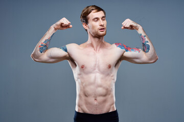 strong male athlete with pumped up arm muscles and tattoo bodybuilder fitness