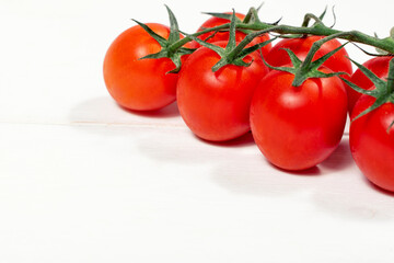 ripe red cherry tomatoes on white wooden background