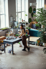 Joyful floral designer cleaning the inside of a polyhedron florarium