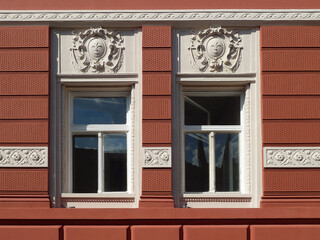 Two windows with ornaments above and on the wall