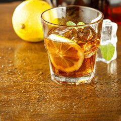 Cold ice tea on wooden desk and wall background of free space 