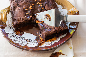 Gooey chocolate cake with chocolate sauce on plate with white doily - obrazy, fototapety, plakaty