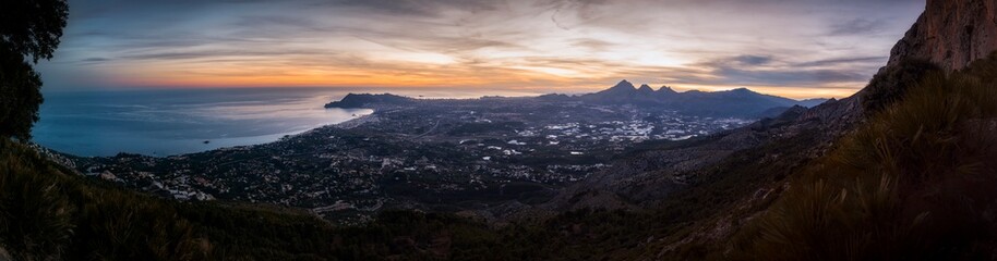 Fototapeta na wymiar Beautiful panorama of the sunset from the mountain. Privileged views of Altea, Benidorm and Alicante from the top of a mountain. Sunset on the mountain, while the sun illuminates the Alicante coast