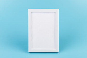 Rectangular blank white picture frame on the blue  background. mockup