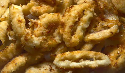 Fried squid cut into rings of golden color. Closeup