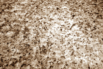 Granite surface as background with blur effect in brown tone.