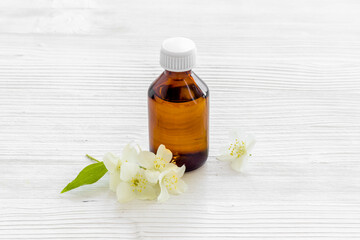 Jasmine flowers with essence oil bottle. Close up