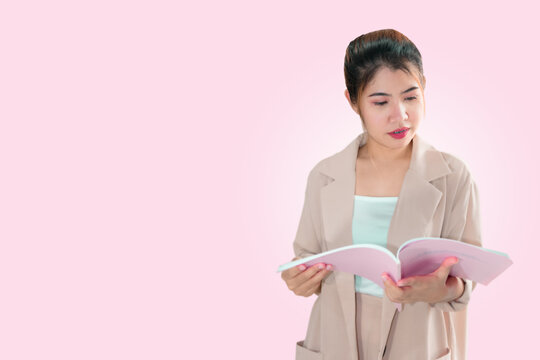 An Asian woman whose face was full of smiles and she was reading a book.