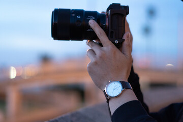 Photographer photo shooting, both hands holding camera. 