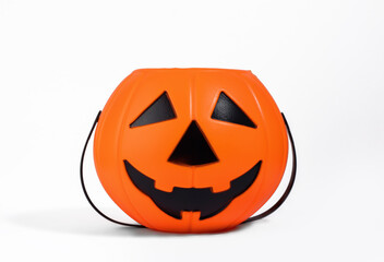 Jack o Lantern orange basket or bucket for sweets isolated on white background with shadow. Halloween celebration and trick-or-treating concept. Sweets collection basket