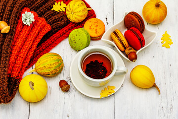 French macarons in autumn colors with cup of hot tea