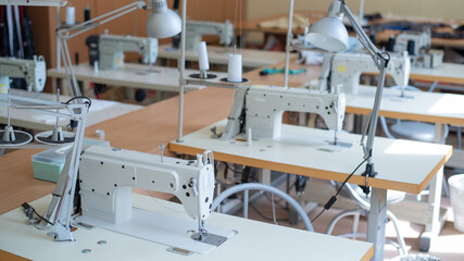 Working environment sewing workshop. Tailoring industry. Empty workplaces of seamstresses