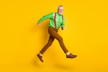 Fototapeta na wymiar Full body profile side photo of cheerful happy old man run go empty space isolated on yellow color background