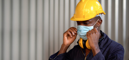 african american worker man wearing protective face mask in industry factory during Coronavirus or...