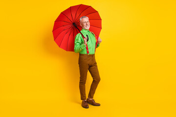Full body photo of nice aged man hold parasol wear spectacles shirt trousers isolated on yellow color background