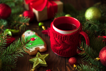 Hot Christmas tea with gingerbread cookie on wooden table. Top view. New Year and Christmas celebration concept.