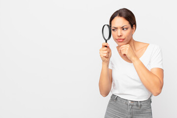 young hispanic woman holding a magnifying glass