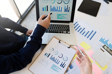 Young Asian business financial team work together in project brainstorm meeting. Cooperate teamwork, strategy planning, small business startup company, or office coworker concept.