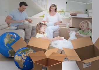 Composition of happy caucasian family in new home with two globes and cardboard boxes