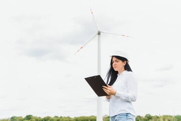 Environmental engineer with a laptop at wind farm