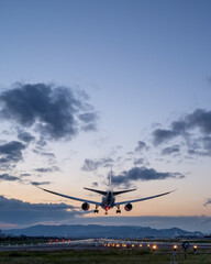 Fototapeta na wymiar 夕焼け背景に着陸する旅客機