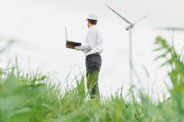 Engineer inspecting Project Manager at the Wind Farm. Man working in the enviromental